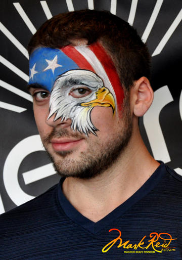 interesting face painting on a man featuring a bald eagle head where the man's eye is also the eagles's
